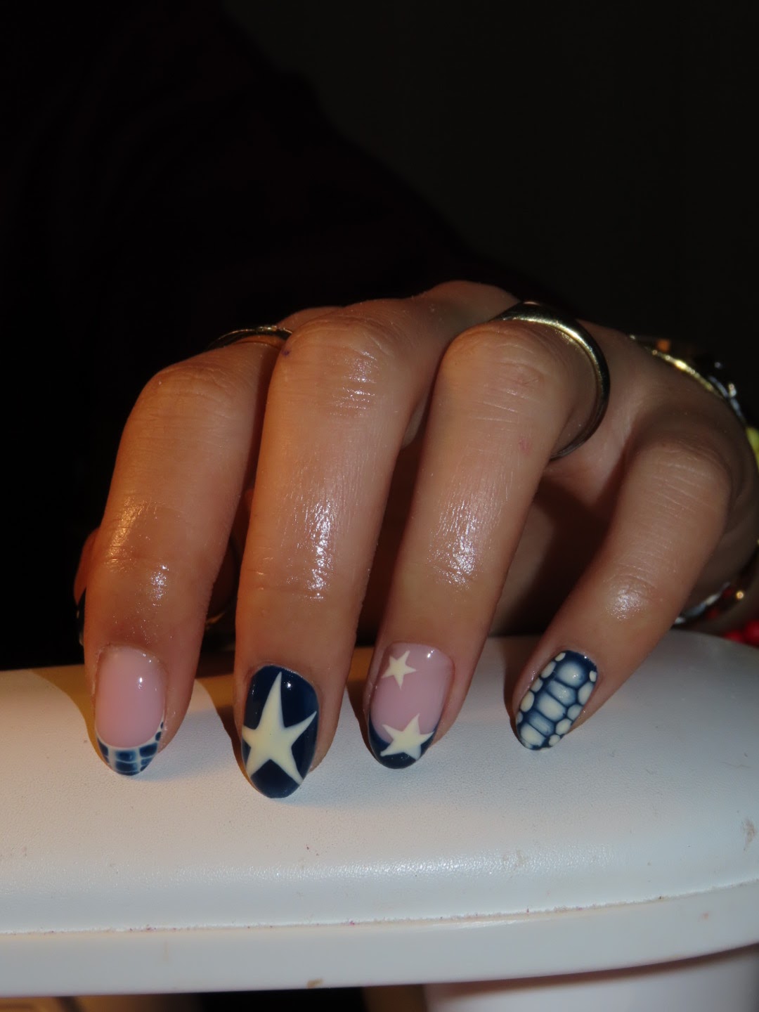 Korte nagels met een witte ster op marineblauw, ruitjes en een roze ster