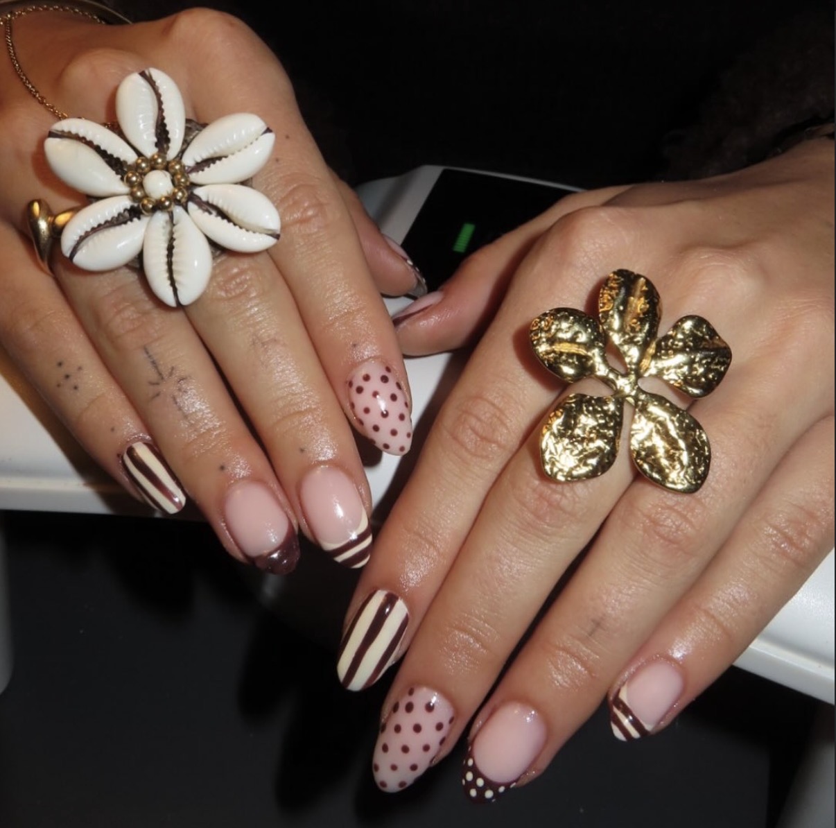 Nude nagels met strepen en stippen, met een grote bloemring