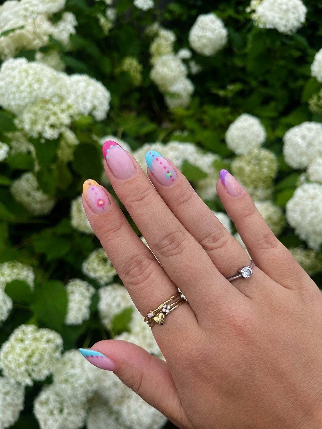 Pastel nagels met chroom, gefotografeerd tegen witte hortensia's