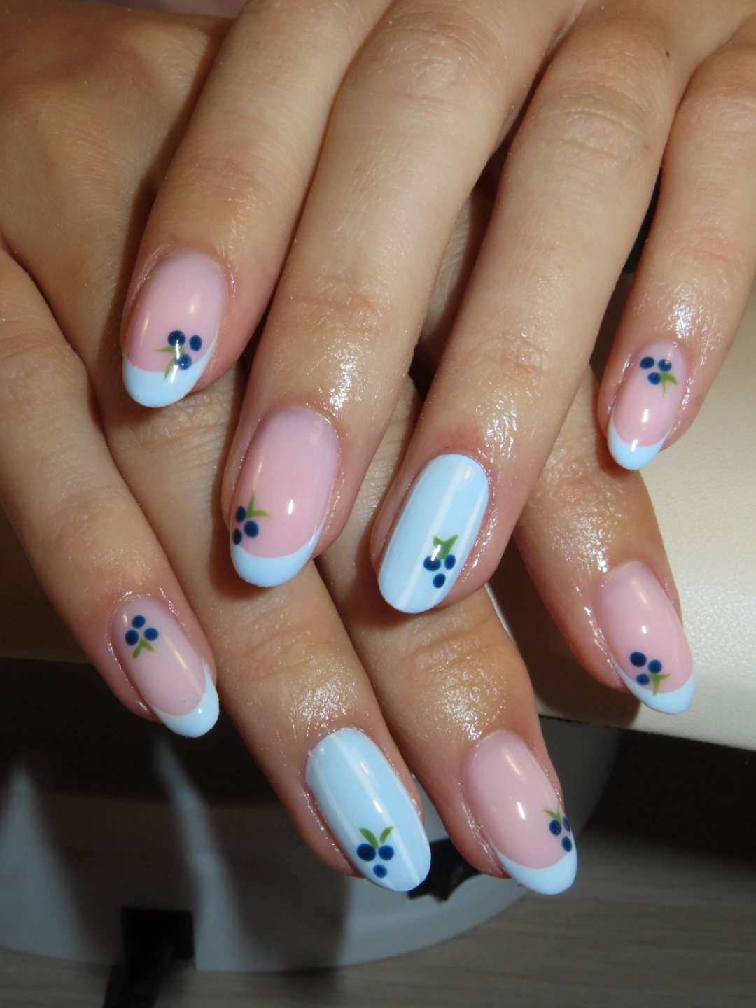 Lichtblauwe nagels met geschilderde blauwe bessen